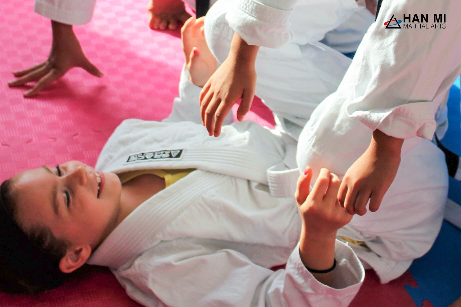 A Youth Jiu-Jitsu student practicing a pin on the mat