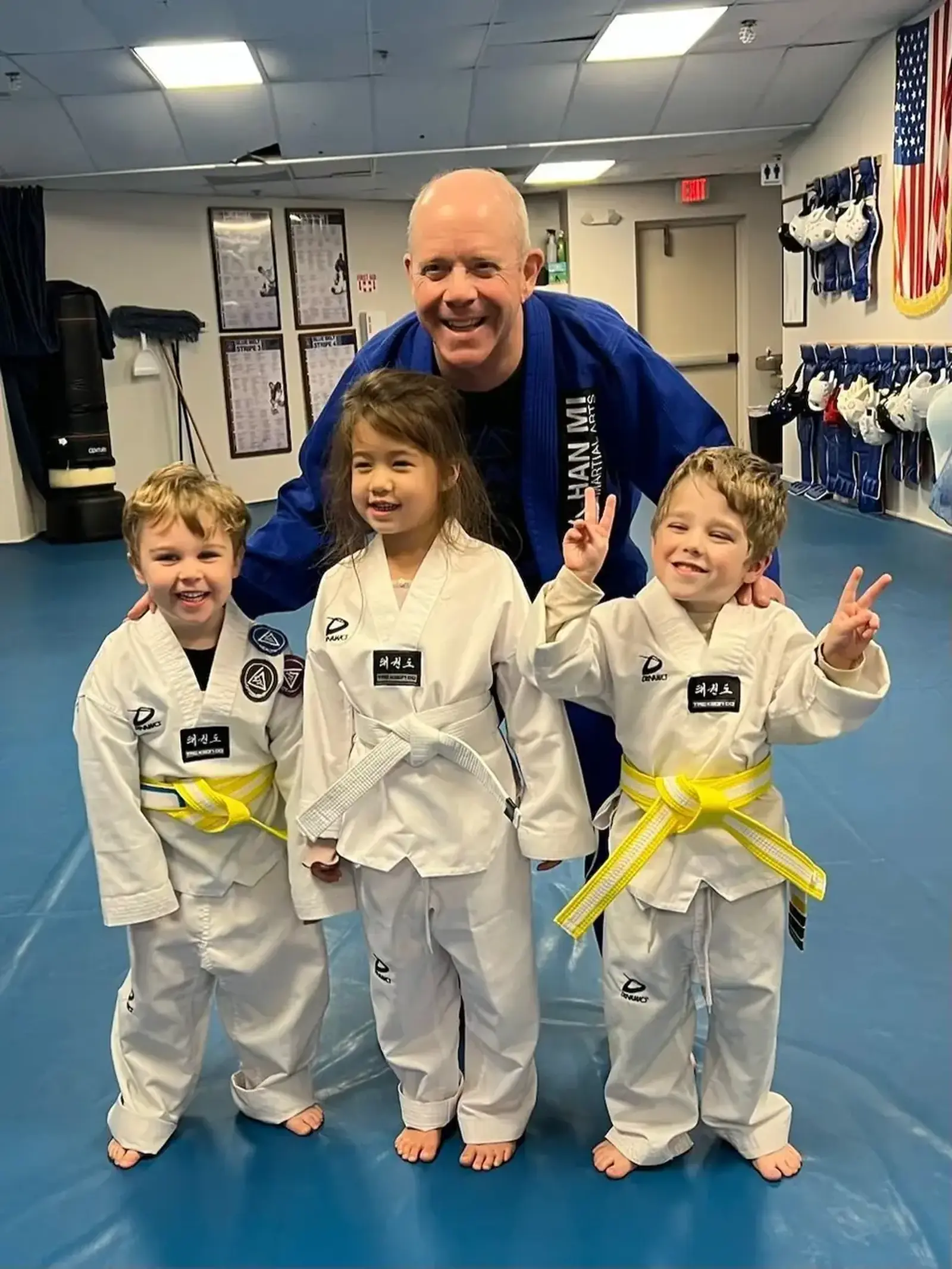 A coach working with three young Little Dragons students