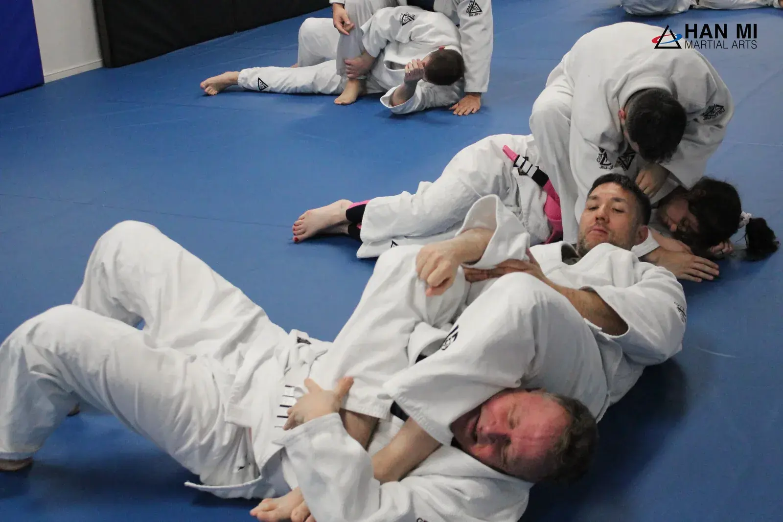Adults practicing jiu-jitsu in gis