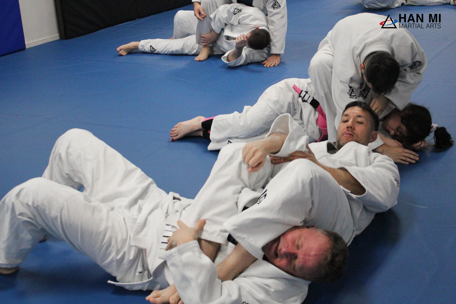 Adults practicing jiu-jitsu in gis
