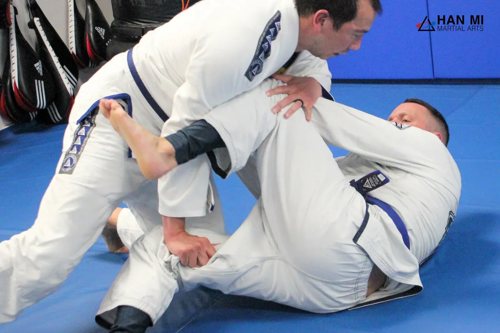 Adult jiu-jitsu students grappling in class