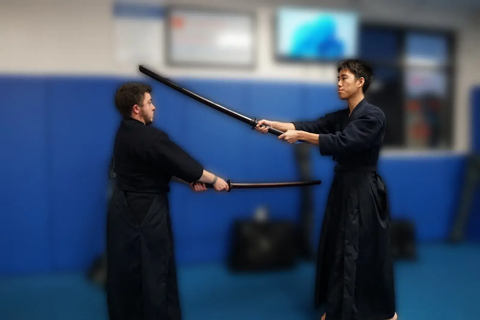 Two kendo students practicing with bokken (wooden swords)