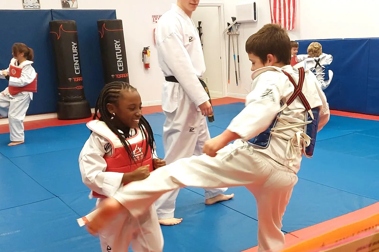 Little Dragons student laughing during a kicking drill