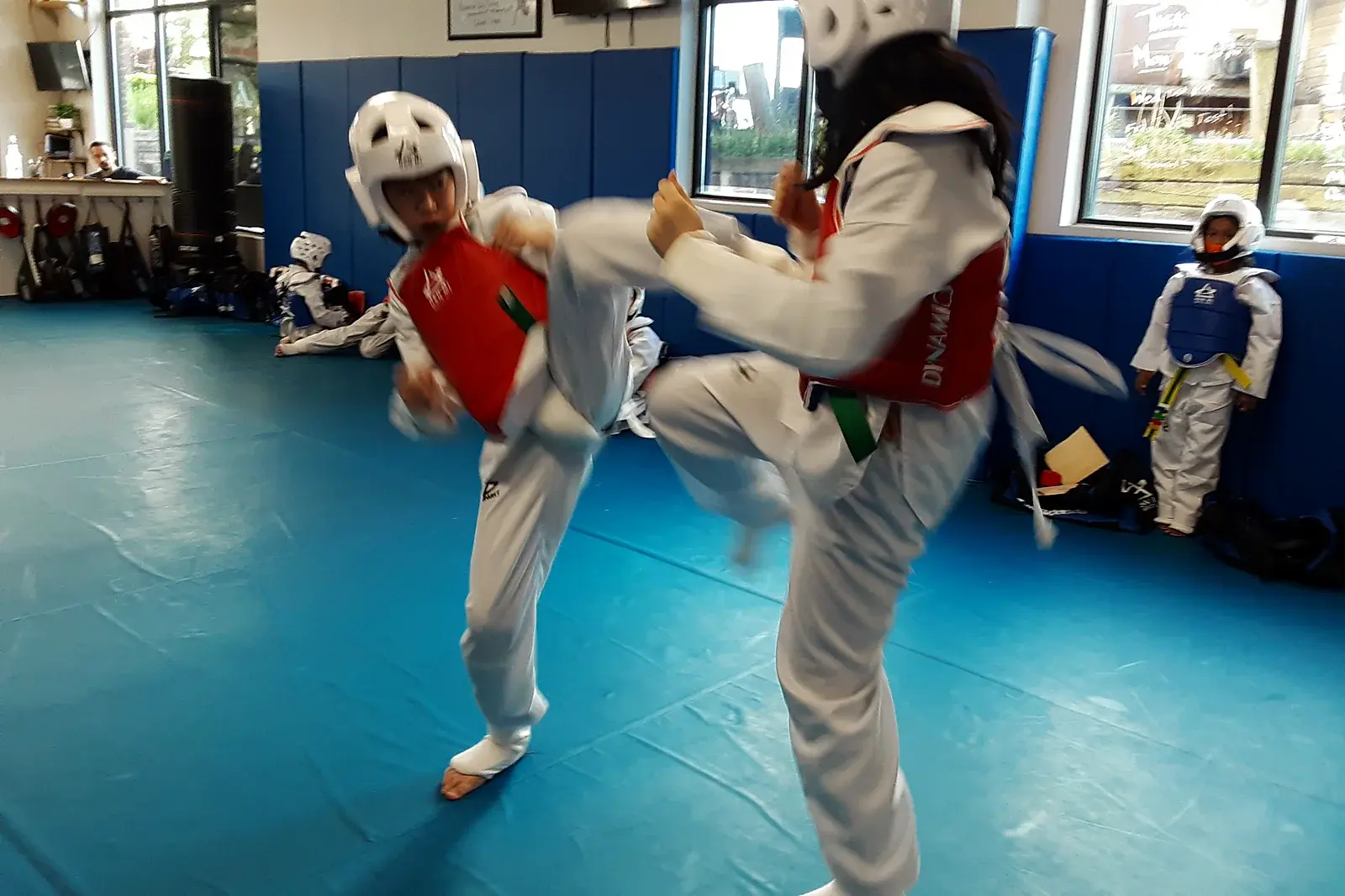 Taekwondo students sparring with a roundhouse kick at Han Mi Martial Arts