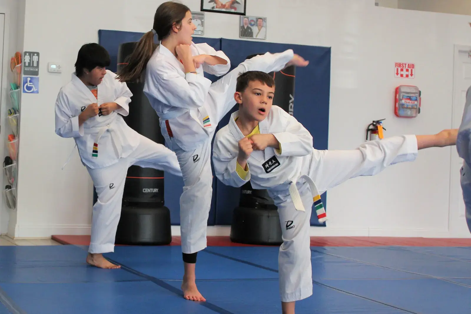 Taekwondo students kicking together