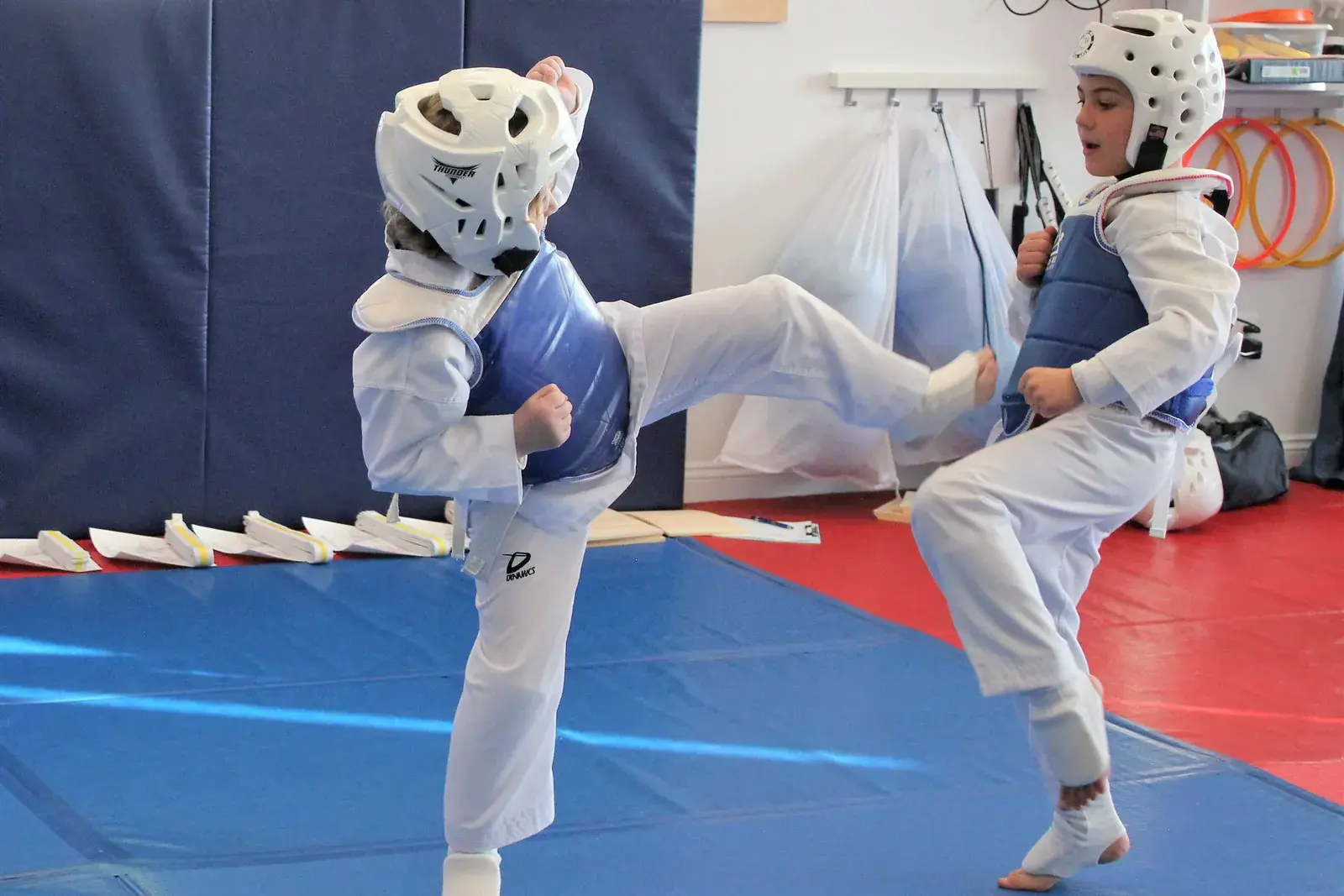Taekwondo students sparring with a roundhouse kick