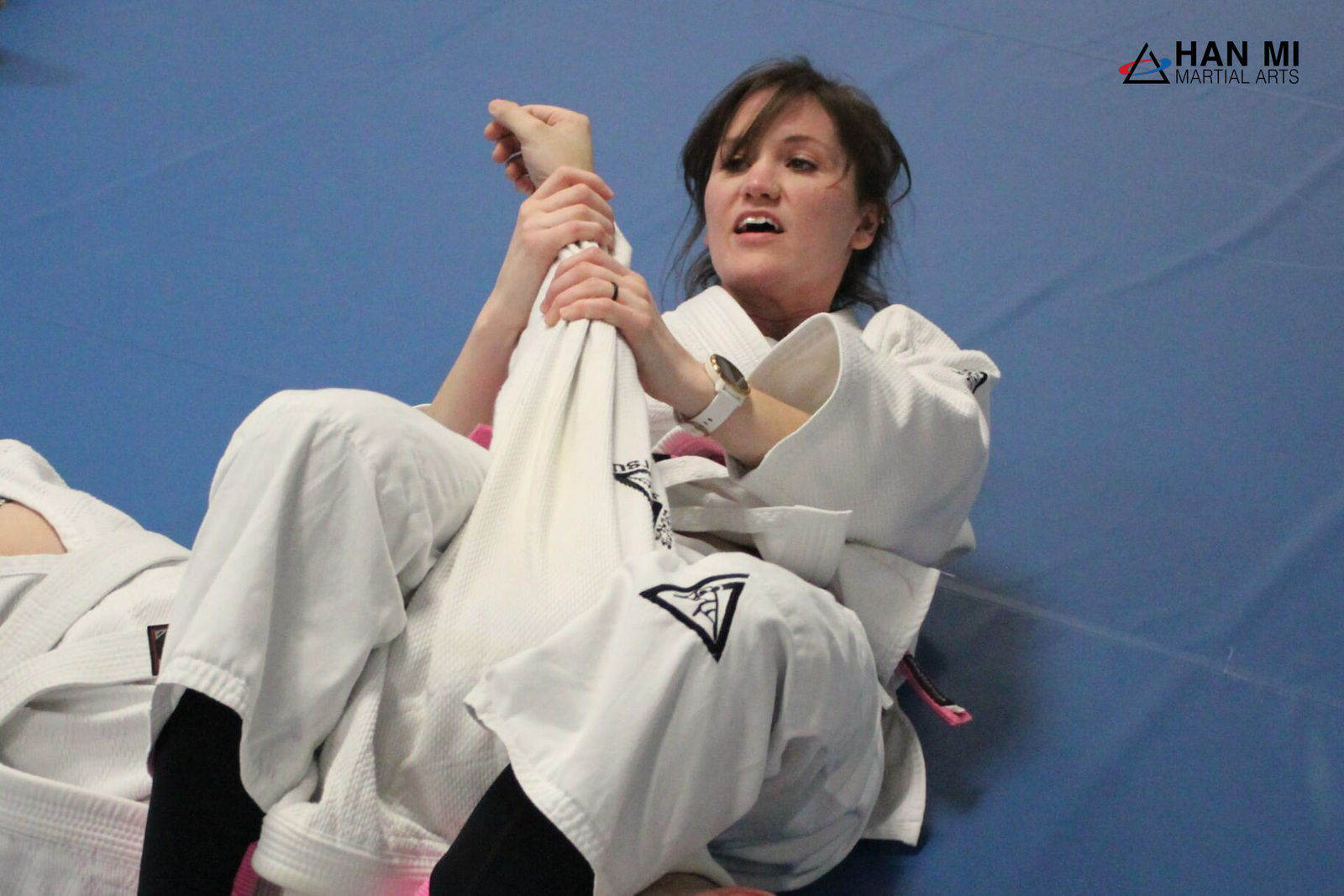 A woman practicing a self-defense position from her back