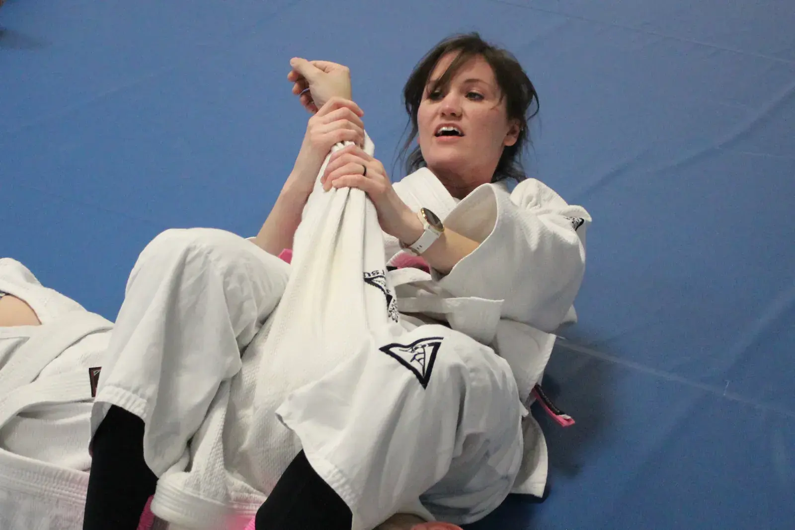 A woman practicing a self-defense position from her back