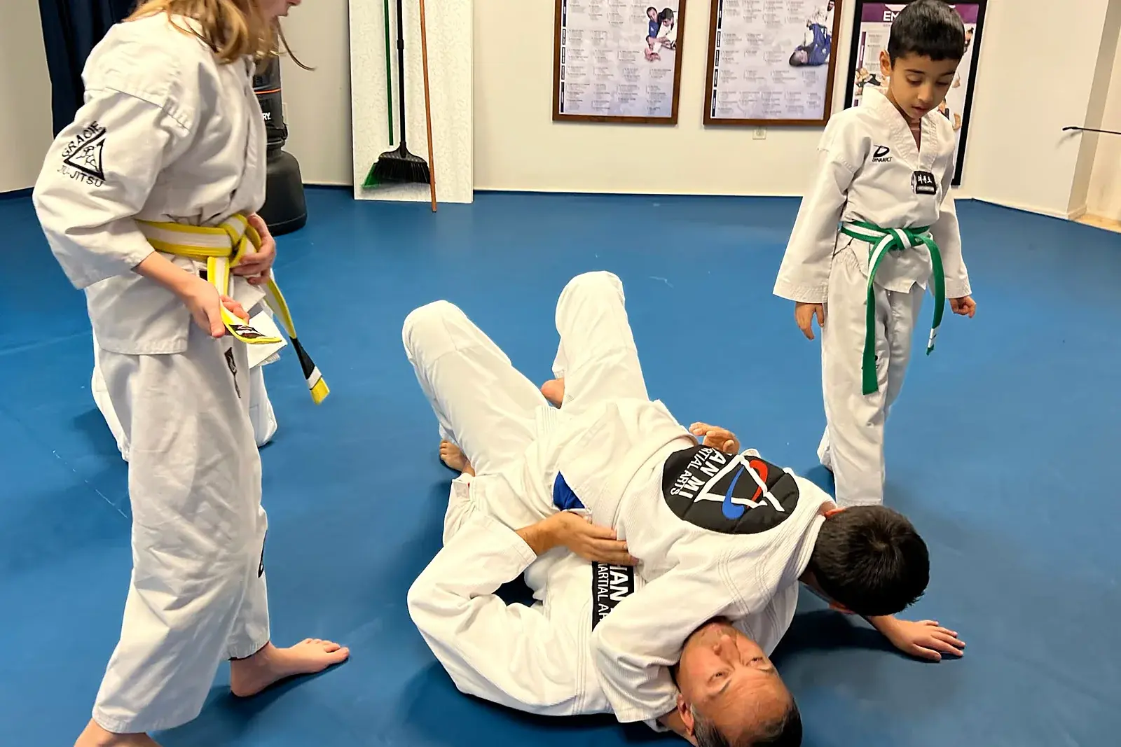 Coach demonstrating a Brazilian Jiu-Jitsu move to kids at Han Mi Martial Arts