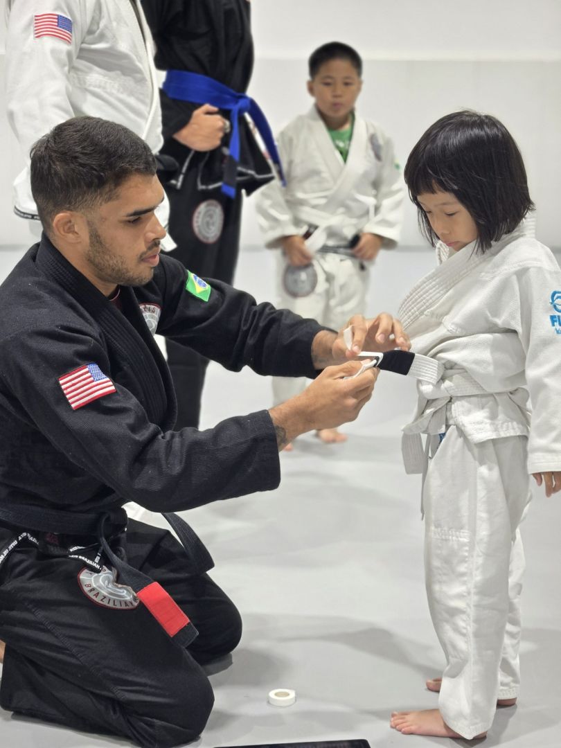 A young student receiving a belt stripe