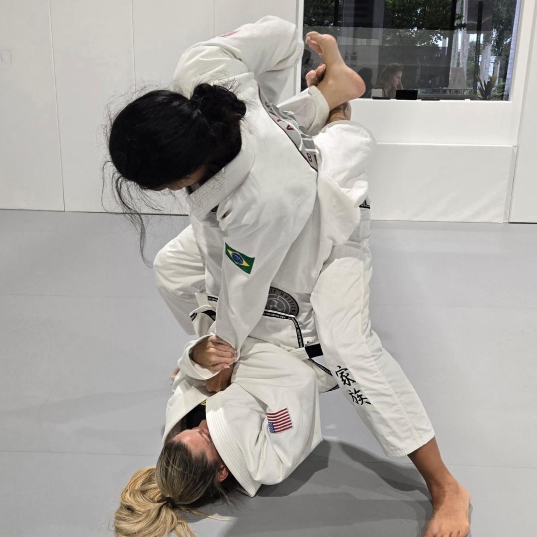 Two women training jiu-jitsu in the gi