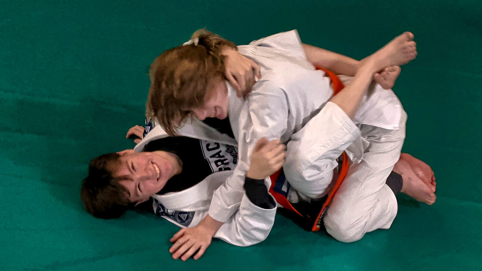 Smiling Jiu-Jitsu student practicing with a training partner at Gracie Jiu-Jitsu Schertz