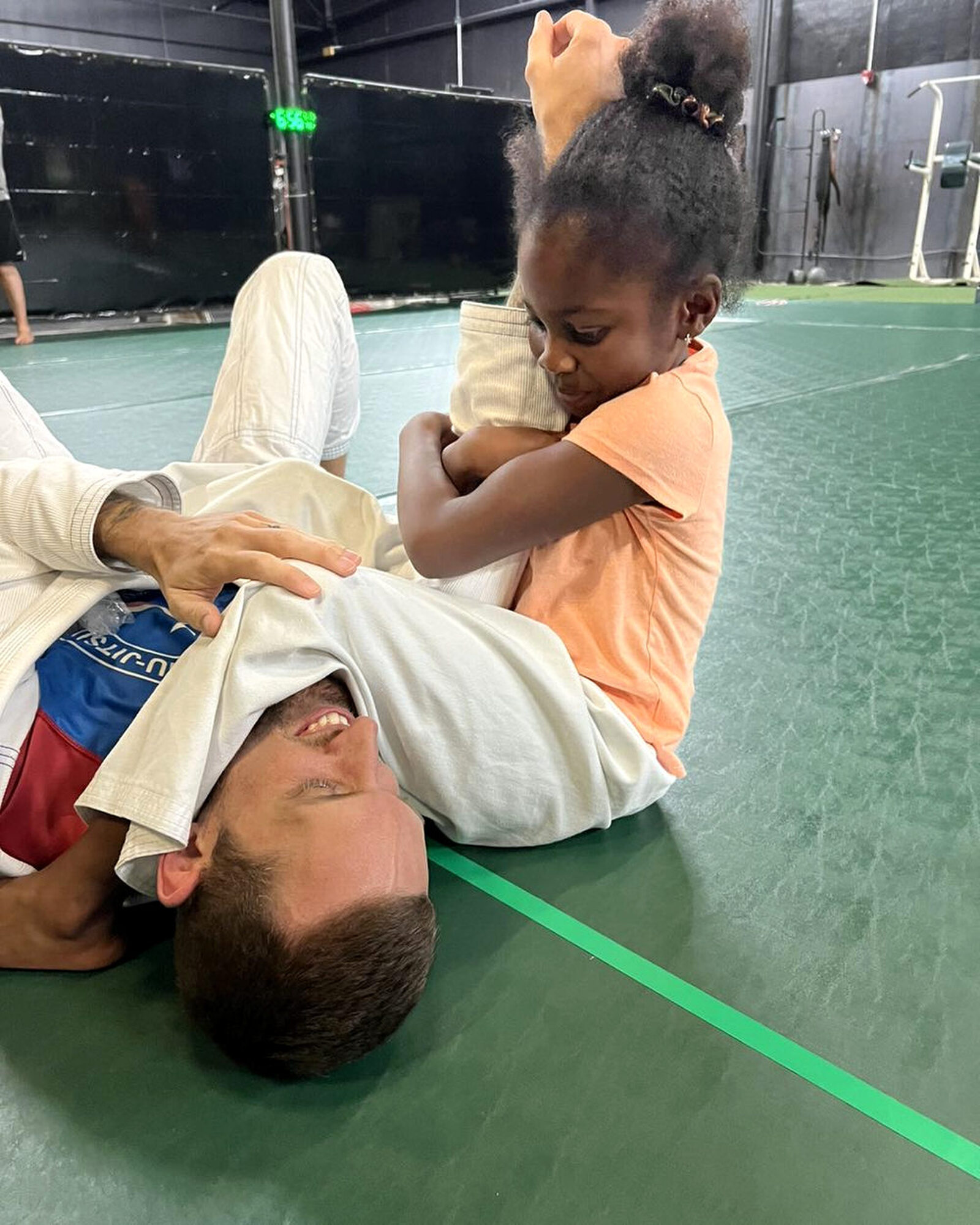 Young student practicing age-appropriate Jiu-Jitsu movements with an instructor