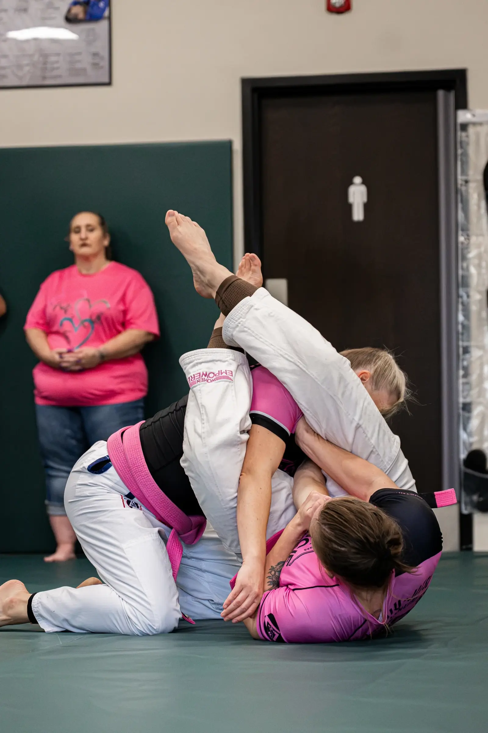 Women demonstrating a ground technique at a self-defense workshop