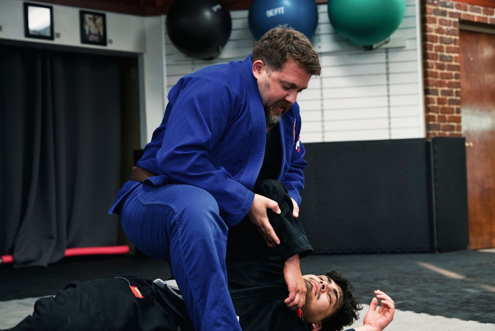 Instructor rolling with a student on the mats at CJJF North Carolina