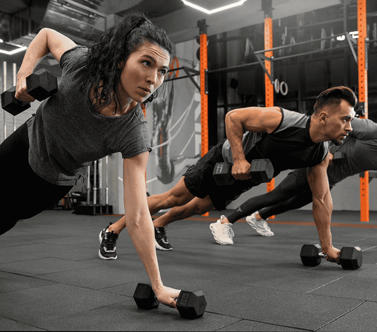 Two athletes training with dumbbells