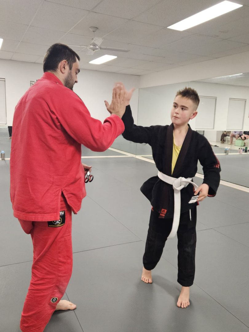 Coach Hamza sharing a high-five with a young student
