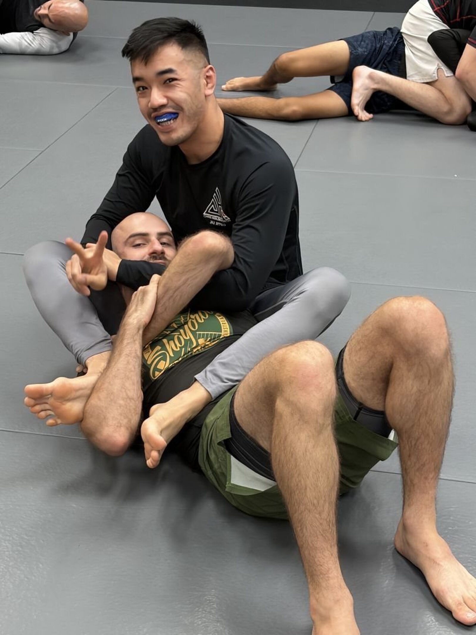 Two training partners smiling during a no-gi roll
