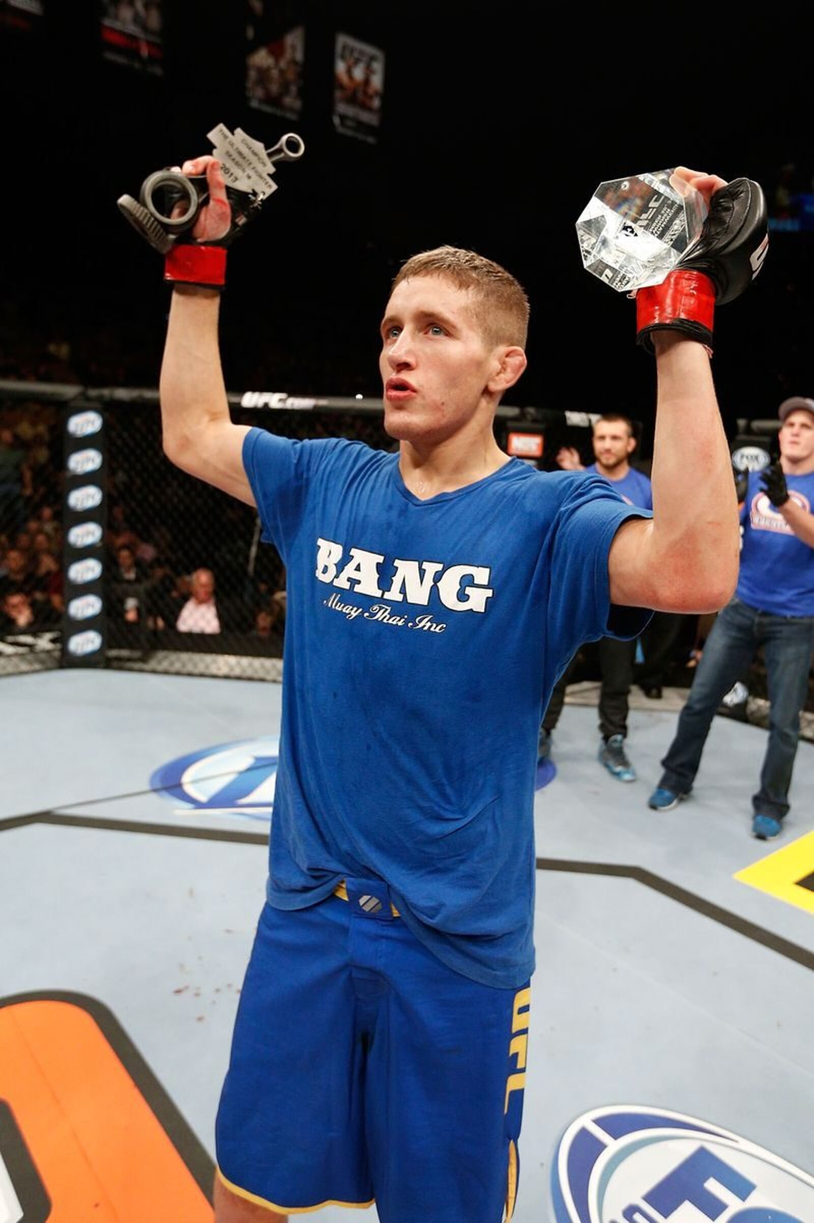 Chris Holdsworth in the Octagon holding his trophies after winning The Ultimate Fighter Season 18