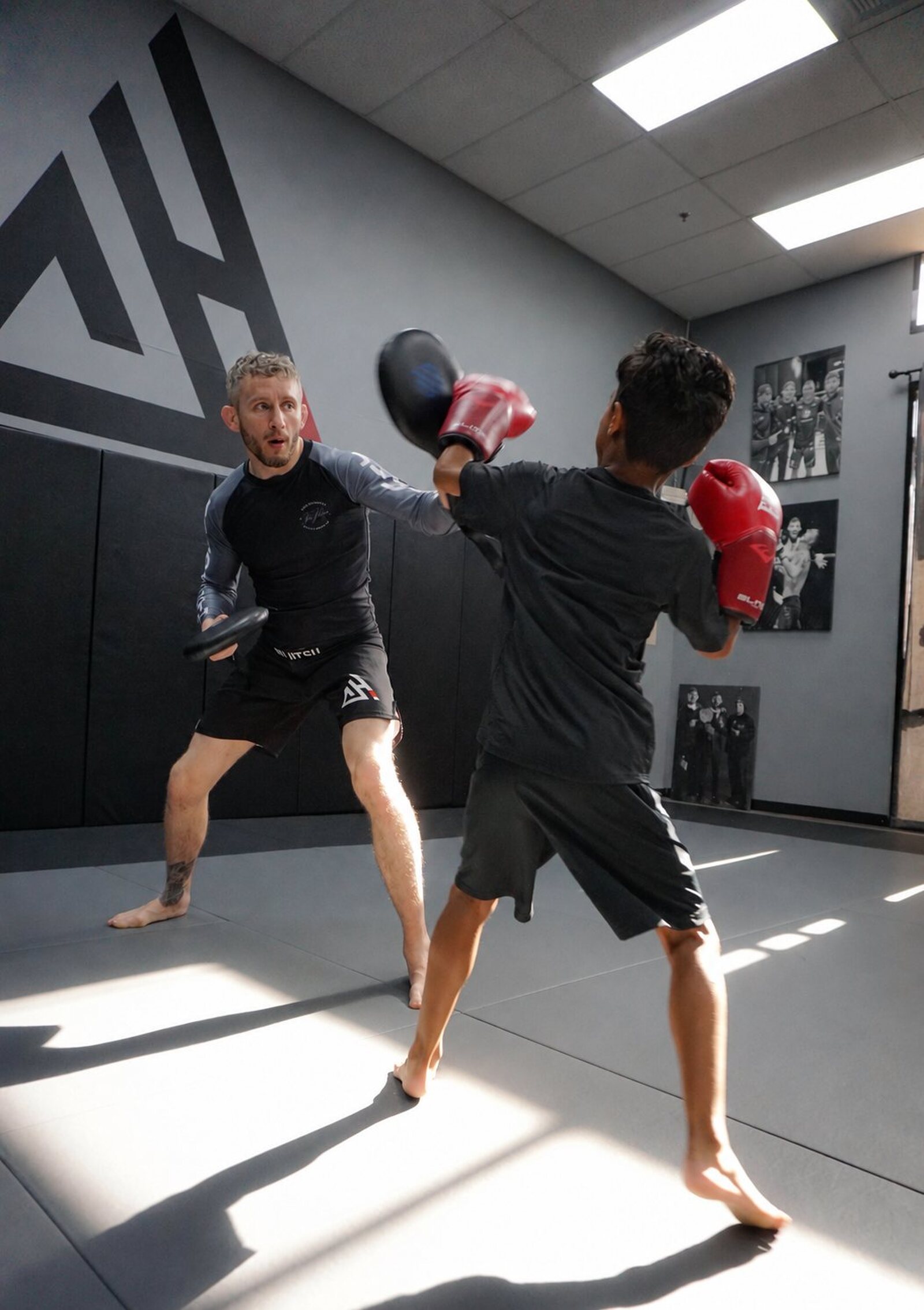 Coach Chris holding pads for a young student in kids striking class