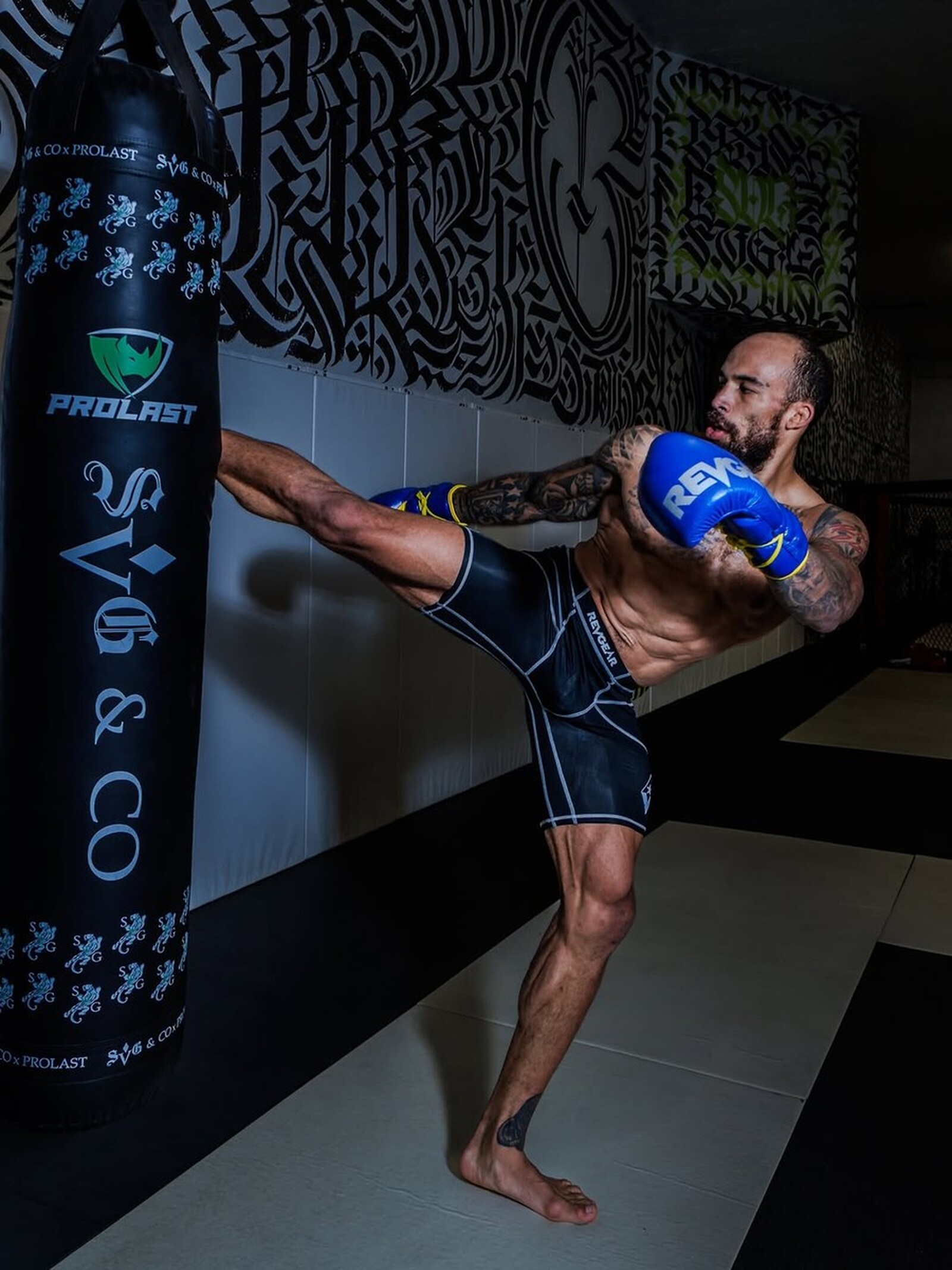 SVG fighter throwing a high kick into the SVG and Co heavy bag